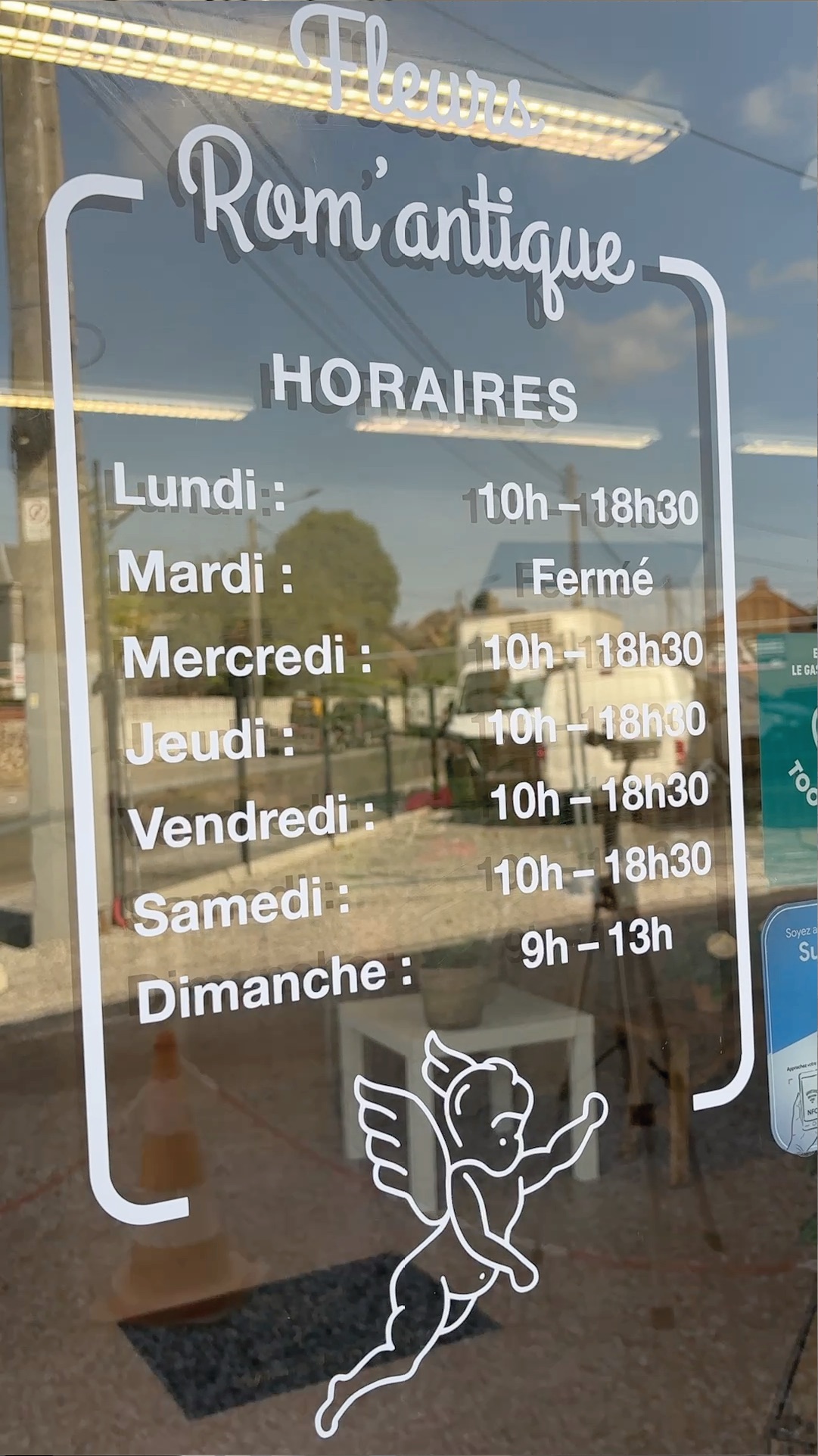 Horaires et identité Rom’antique en lettrage blanc sur vitrine